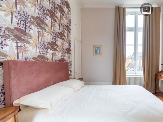 Une chambre rose et or dont la tête de lit en tissus, les rideaux e tla tringle sont réalisées sur mesure par Eveline Pezé et fils.